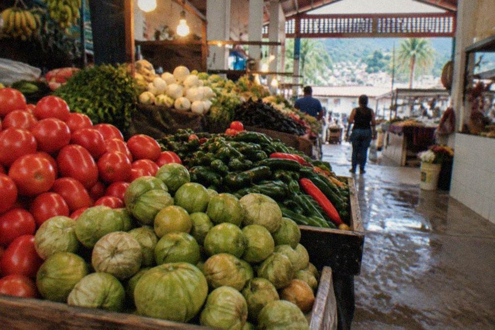 Fresh produce and chiles stacked at an indoor Puerto Vallarta market stall