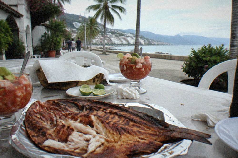 Freshly grilled fish and seafood dishes arranged on an outdoor restaurant table