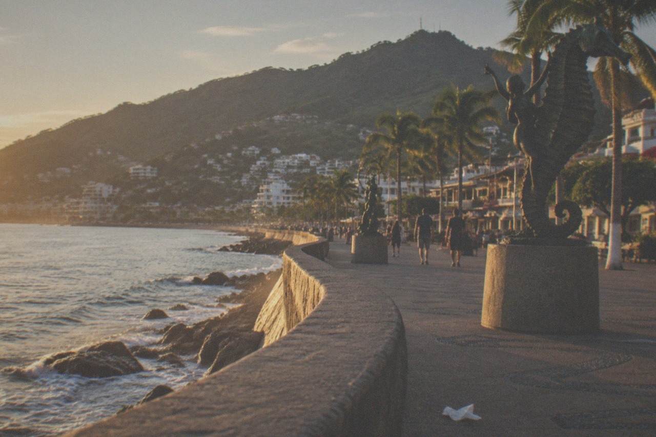 Golden hour over the Puerto Vallarta Malecon boardwalk with the bay and hills beyond