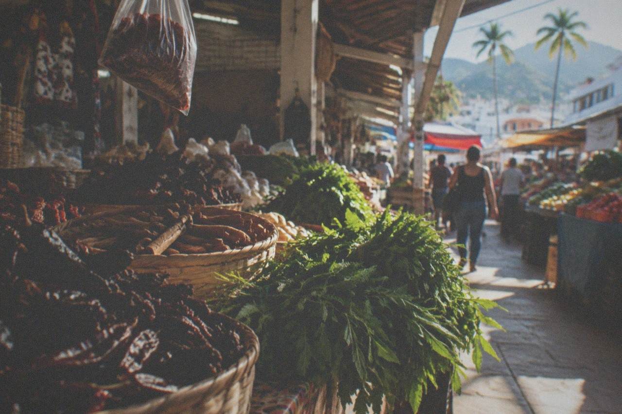 Fresh produce and chiles displayed on a market stall counter in warm daylight