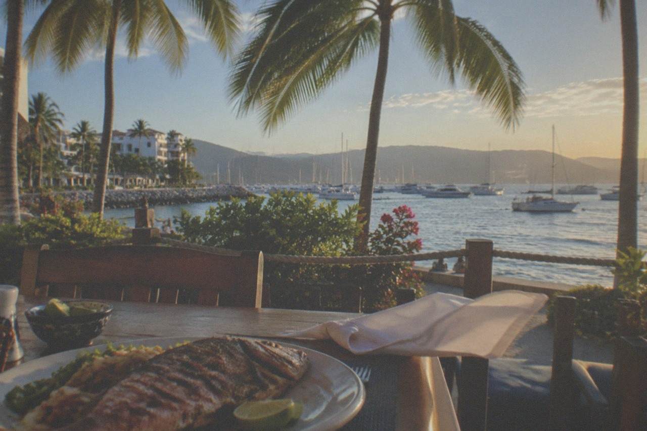 Grilled snapper and lime wedges on a beachfront table overlooking Banderas Bay