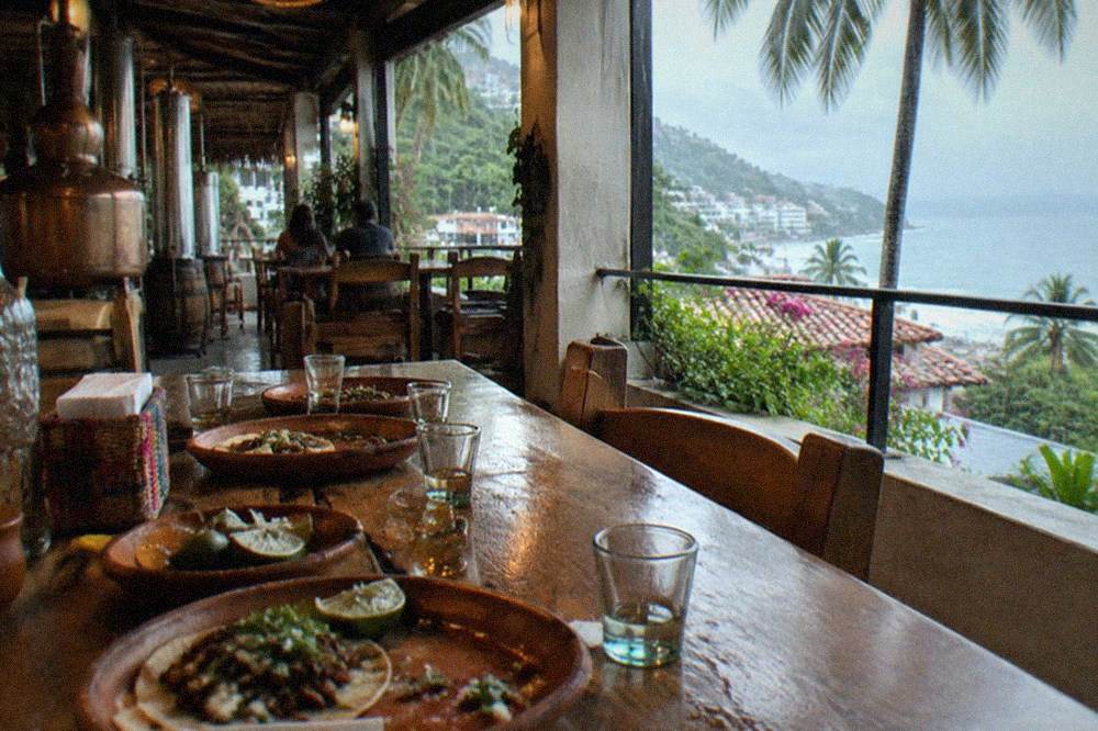 Table set with tacos, mezcal glasses and lime wedges at a Puerto Vallarta tasting