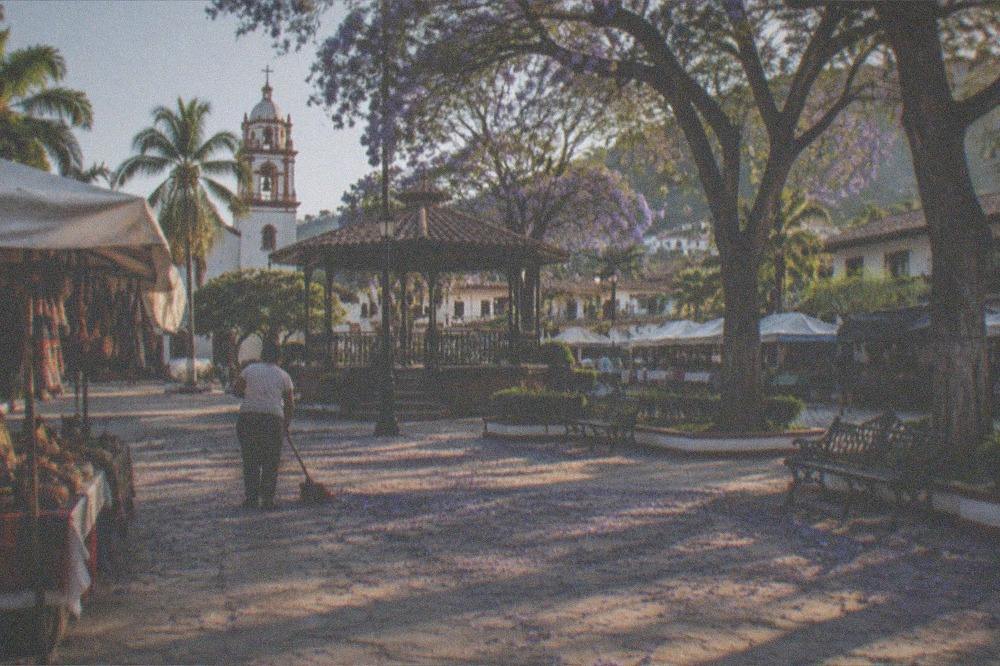 Plaza in a Puerto Vallarta neighborhood with food stalls under shade in late afternoon light