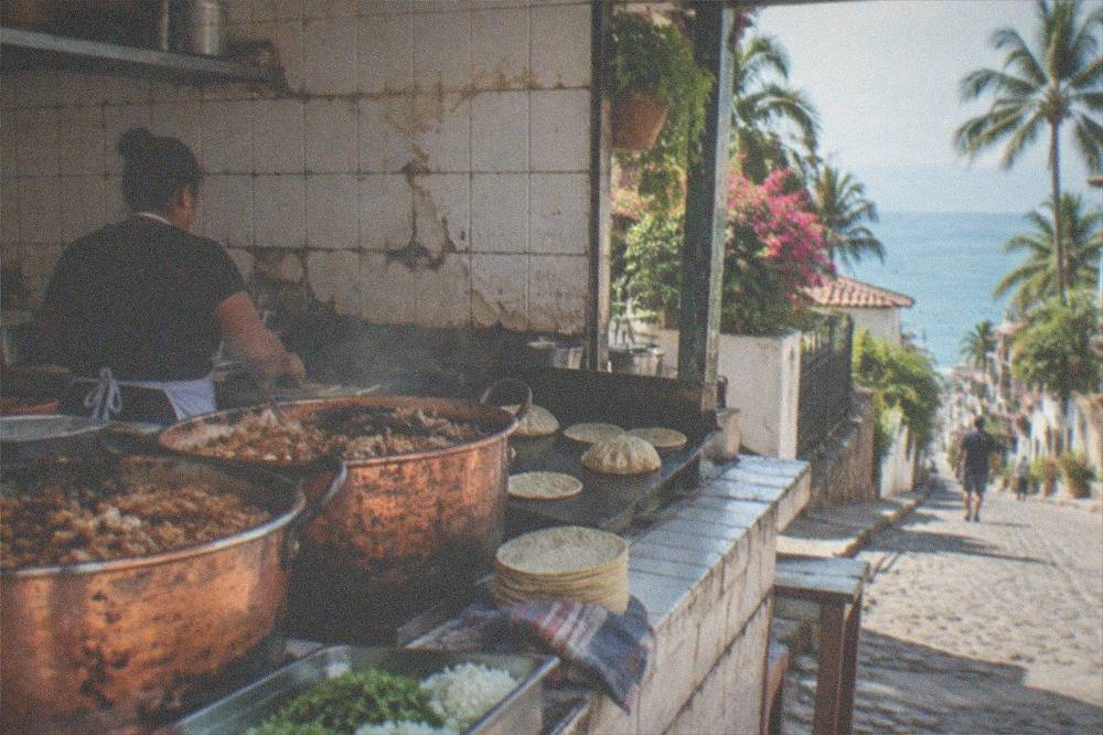 Family-run taqueria counter with carnitas in copper pots and fresh corn tortillas on the griddle