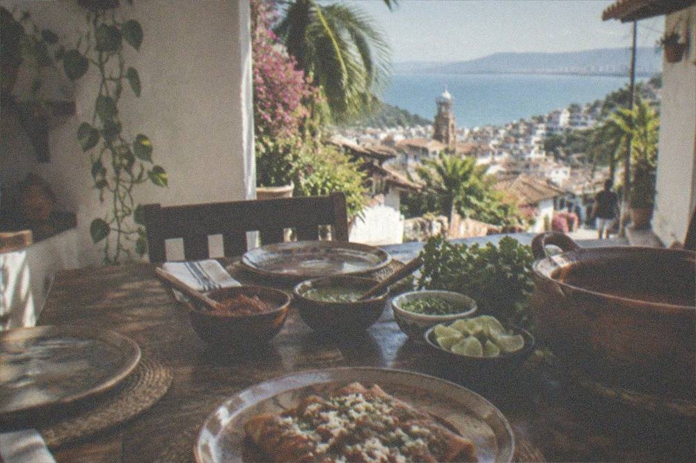 A home kitchen table set with salsas, limes, cilantro and prepared enchiladas ready to serve