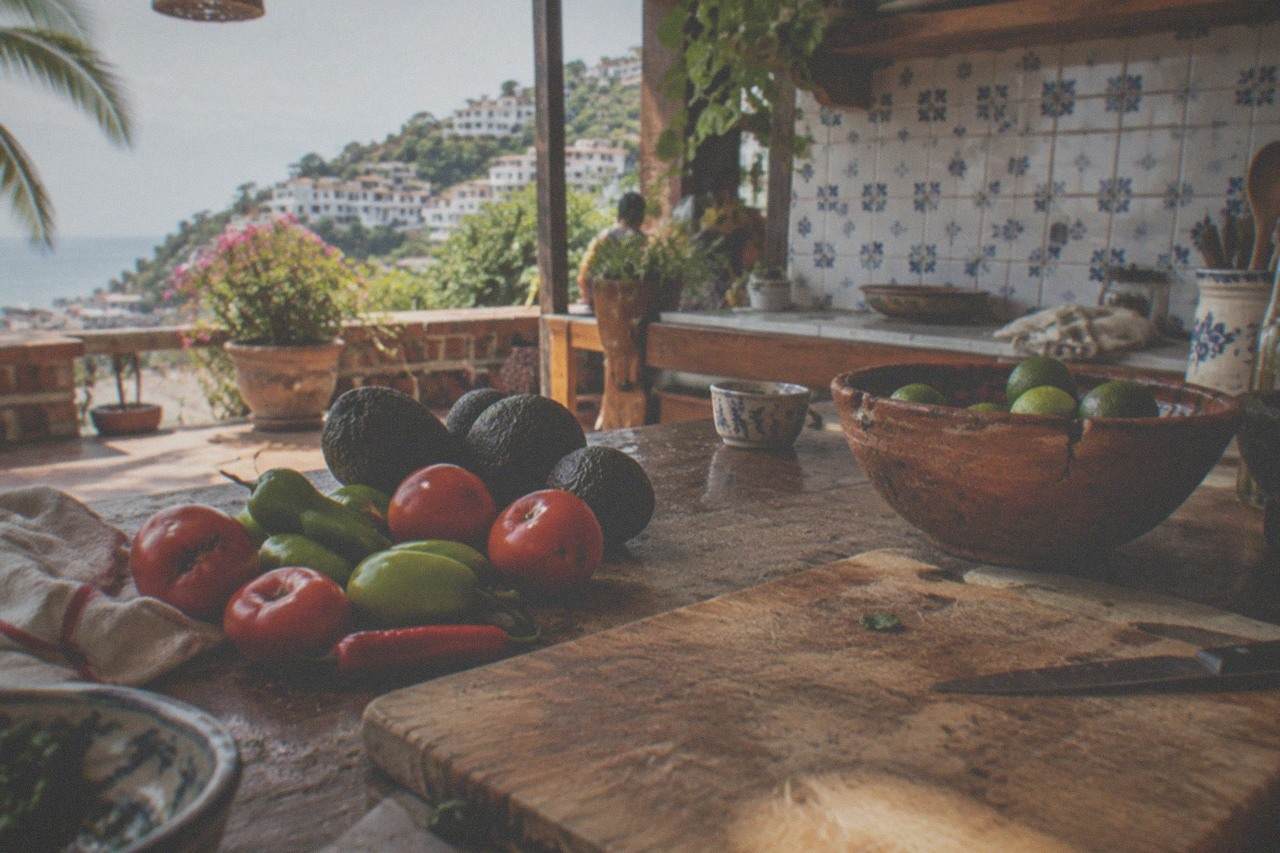 Fresh produce and chiles arranged on a rustic market stall counter under warm light