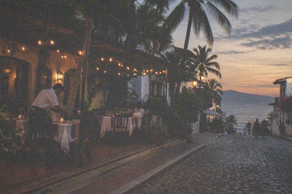 Cobblestone street in Old Town Puerto Vallarta with restaurant tables at dusk