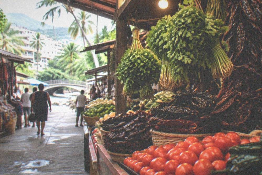 Market stall displaying stacked fresh produce, chiles and hanging bunches of herbs under warm lights